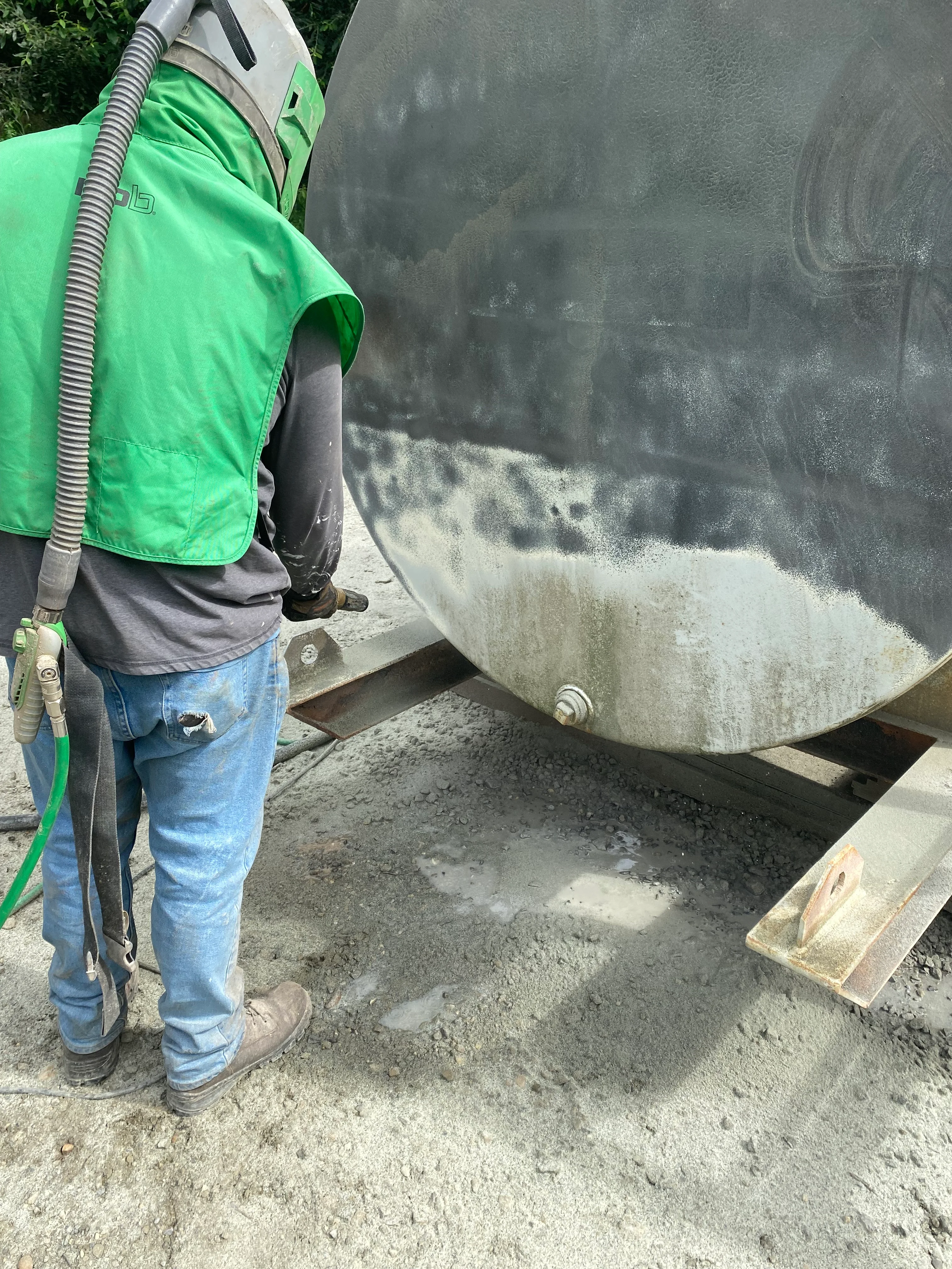 Pressure washing concrete surface with industrial equipment and hose